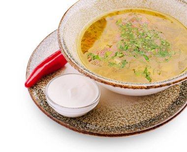 Sıcak bir kase çorba taze otlarla süslenmiş bir tabakta oturur ve yanında da küçük bir tabak ekşi krema ve serin bir günde tadını çıkarmaya hazır kırmızı biber vardır..