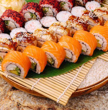 Çeşitli suşilerle dolu canlı bir tabakta zengin tatlar ve taze malzemeler sergileniyor. Konuklar özel bir gün veya birlikte yemek yerken lezzetli çeşitliliğin tadını çıkarırlar..