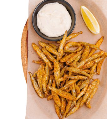 Bir tabak altın, kızarmış balık çubuğu yanında küçük bir kase kremalı sos ve tat katmak için taze bir limon dilimi servis edilir. Paylaşmak ve eğlenmek için mükemmel.