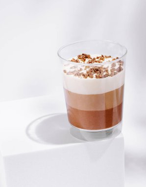 Yumuşak çikolata katmanları ve çırpılmış krema temiz bir bardakta servis edilir. Üzerine çıtır çıtır parçalar serpiştirilir. Her durum için mükemmel bir ziyafet yaratır..