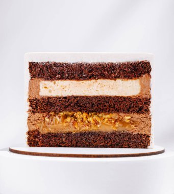 Yozlaşmış çikolatalı pasta zengin dolgularını gösterir. Pastada kremalı beyaz dolgu ve pürüzsüz karamel merkezli koyu çikolata katmanları yer alıyor ve hoşgörüyü teşvik ediyor..