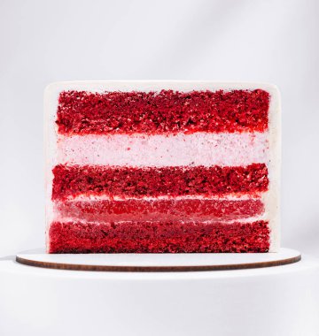 Bu kırmızı kadife pasta birkaç kat canlı kırmızı sünger ve kremalı krema içerir. Basit, yuvarlak bir stantta oturuyor, zengin rengini ve çekici dokusunu vurguluyor..