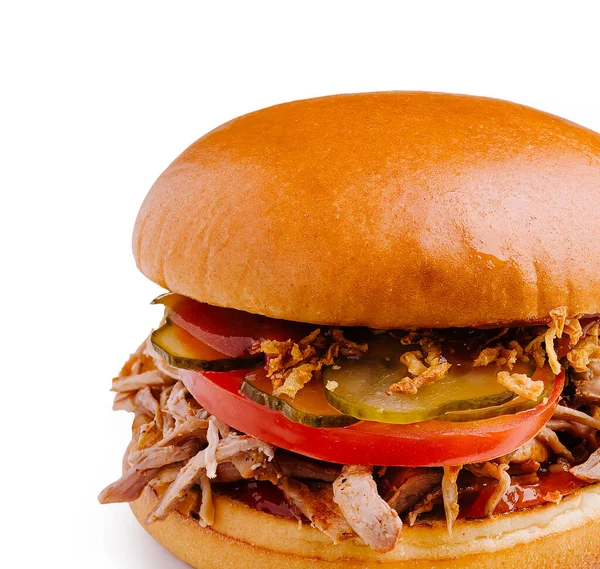 Çekilmiş domuz sandviçi taze domates ve turşuyla kaplıdır. Yumuşak, altın çörek yumuşak, lezzetli et ve kızarmış soğan tutar. Tatmin edici bir yemek için mükemmeldir..