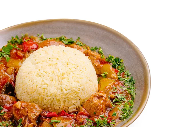 Lezzetli tavuk güveciyle dolu bir kase. Yanında da taze otlarla süslenmiş kabarık beyaz pirinç. Sebzelerin canlı renkleri yemekle uyumlu..