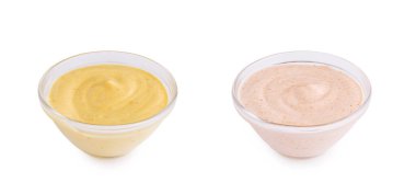 İki küçük cam kase farklı kremalı soslar içeriyor. Bir kasede sarı sos, diğerinde ise pembe sos var. Soslar pürüzsüz ve davetkar..