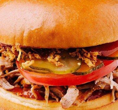 Yumuşak et, çıtır soğan, turşu ve domatesli taze yapılmış domuz etli sandviç. Bu lezzetli yemek öğle ya da akşam yemeği için mükemmel..