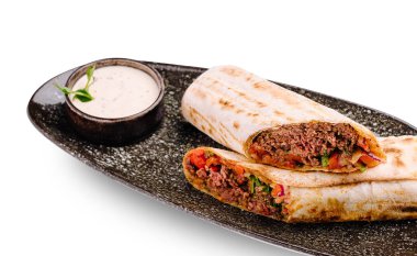 Baharatlı ambalajlar taze et ve taze sebzelerle doludur. Süslü bir tabakta kremalı sosla servis edilir. Lezzetli bir aperatif ya da günün her saatinde sıradan bir yemek için mükemmel..