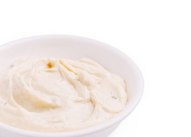 Bir kase kremalı sos temiz beyaz bir yüzeye oturur. Yumuşak dokusu zengin tatlar sunuyor. Atıştırmalık ve yemeklerin yayılması ya da eşleştirilmesi için mükemmel..