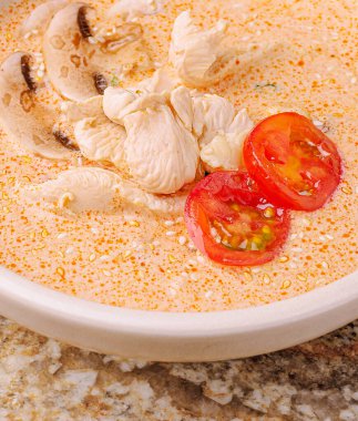 Sıcak bir kase tavuk çorbası taze tavuk parçaları, taze domates ve baharat karışımı içerir. Rahatlatıcı yemek günün her saatinde sıcak bir yemek için mükemmeldir..