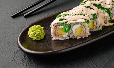 Bu suşi rulosunda çıtır çıtır bir dolgu ve yanında wasabi olan parlak siyah bir tabakta servis edilen taze yeşillikler var. Hafif bir yemek ya da Japon restoranında atıştırmak için mükemmel..