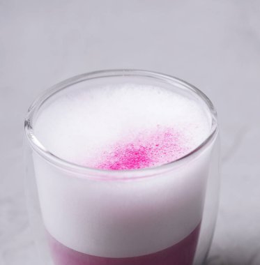 Güzel katmanlı bir içecek, üzerinde beyaz köpük bulunan canlı pembe bir taban gösterir.. 