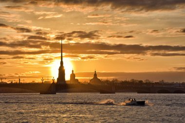 Neva Nehri üzerinde gün batımı. Güneş ufuktan batıyor. Gökyüzü ve su kırmızıya boyandı..