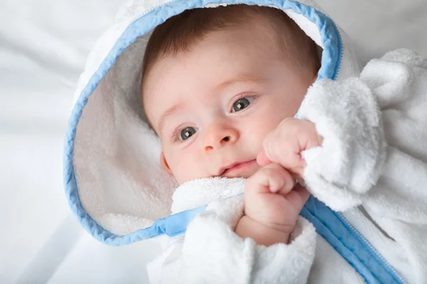 Mooie kleine baby met grote ogen witte handdoek op zoek naar iets in — Stockfoto