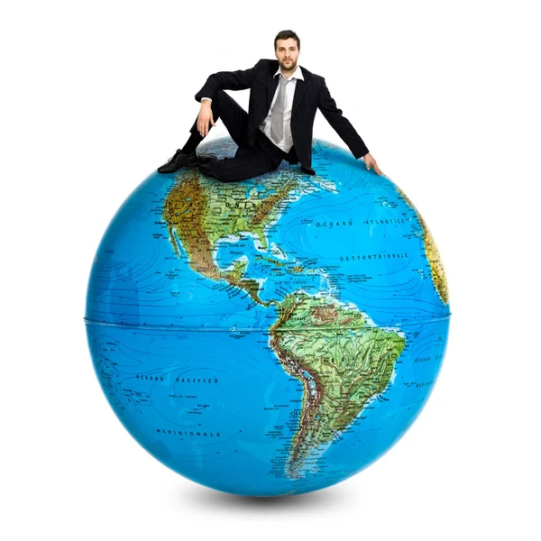 Businessman own the world standing on a globe isolated on white — Stock Photo, Image
