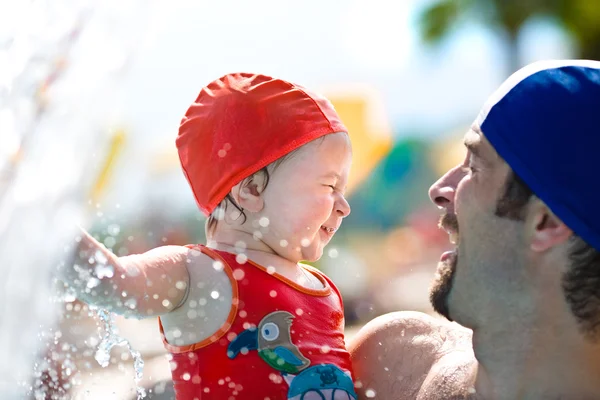 Aranyos boldog baba szórakozni az apja medence partján nyáron — Stock Fotó