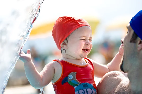 Lindo bebé feliz divertirse con su padre en la piscina durante el verano — Foto de Stock