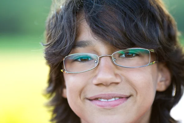 Joven feliz chico con el pelo largo y gafas al aire libre retrato — Foto de Stock