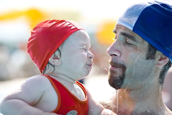 Lindo bebé feliz divertirse con su padre en la piscina durante el verano —  Fotos de Stock
