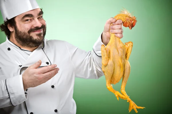 Улыбаясь счастливый шеф-повар приготовить курицу изолирован на зеленый — стоковое фото