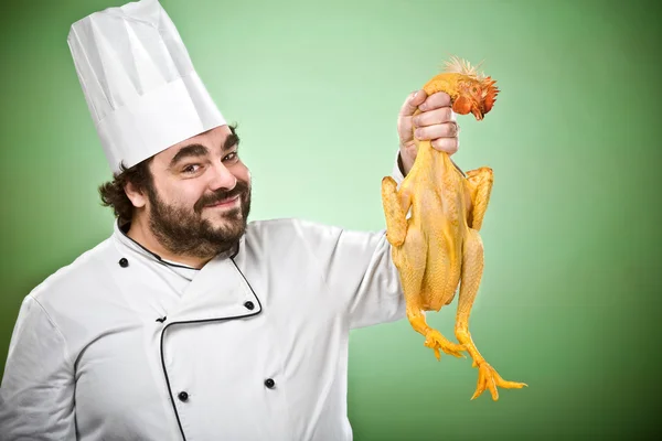 Sorrindo chef feliz cozinhar frango isolado no verde — Fotografia de Stock