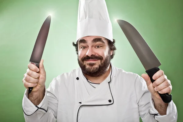 Улыбка шеф-повара приготовления пищи с ножом изолированы на зеленый — стоковое фото