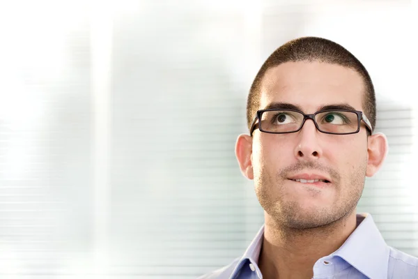 Jeune homme d'affaires douteux avec des lunettes penser au bureau — Photo