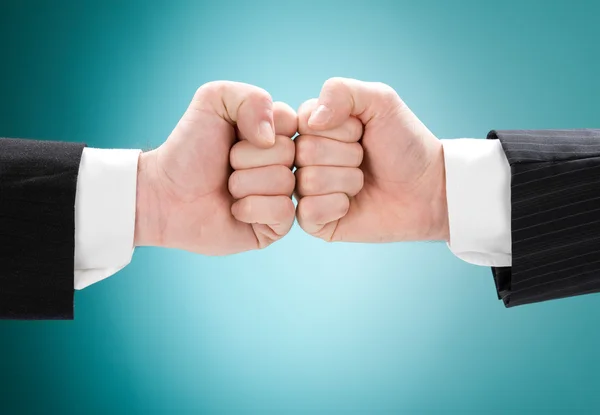 Businessman competition fist against fist isolated on blue — Stock Photo, Image