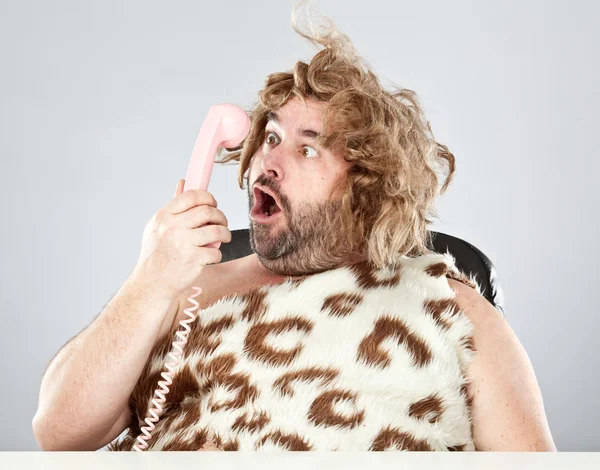 Потворний грубий доісторичний чоловік розмовляє по телефону — стокове фото