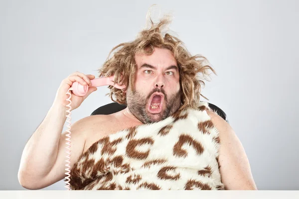 Feo grosero hombre prehistórico con el teléfono en el pelo — Foto de Stock