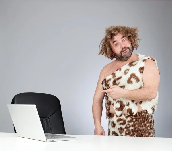 funny perplex prehistoric man using laptop