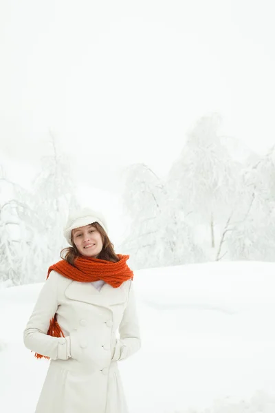 Schöne entspannte Frau mit rotem Schal in einer verschneiten Landschaft — Stockfoto