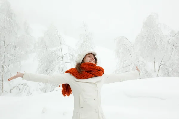 Bela mulher relaxada com cachecol vermelho em uma paisagem nevada — Fotografia de Stock