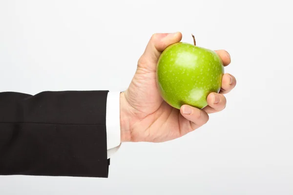 Zakenman hand met groene appel geïsoleerd op grijs — Stockfoto