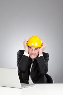 Genç mühendis sarı kask ve gri izole laptop ile sağır