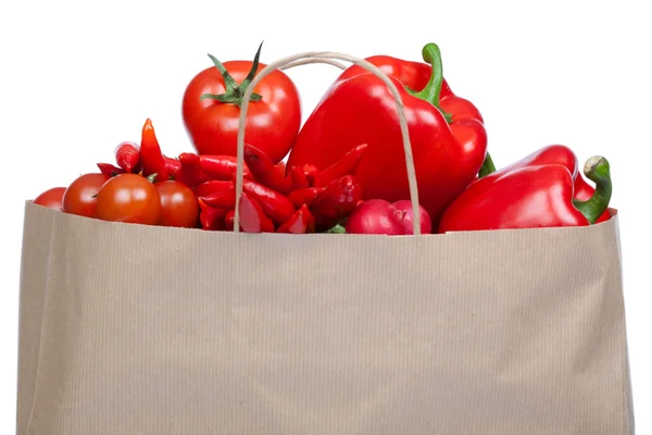 Red tasty vegetable composition set in paper shopping bag isolated white — Stock Photo, Image