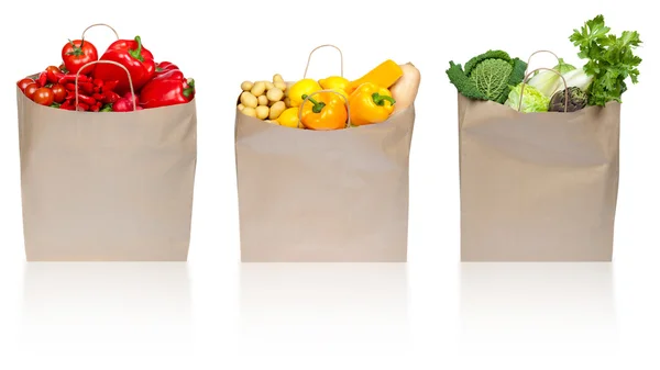 Roșu verde galben compoziție de legume în sacul de cumpărături de hârtie izolat pe alb — Fotografie, imagine de stoc