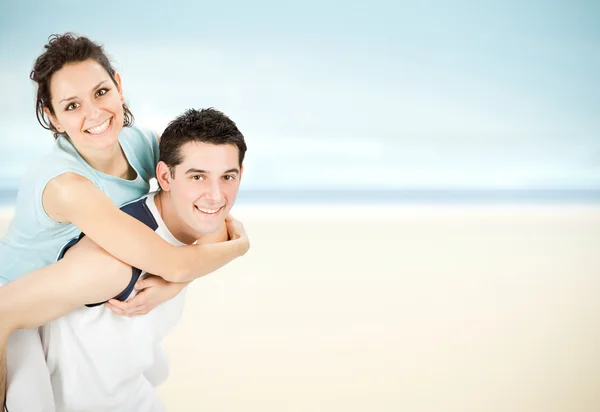 Young beautiful sport couple hug on seaside background — Stock Photo, Image