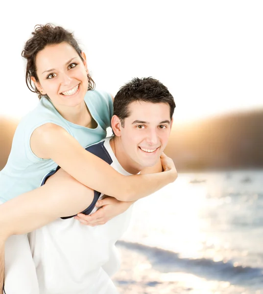 Young beautiful sport couple hug on seaside background — Stock Photo, Image