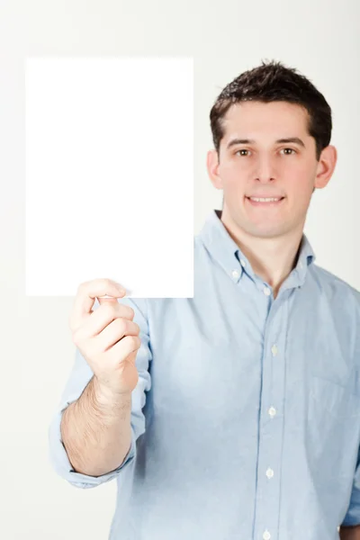 Молодий красивий щасливий чоловік тримає білий документ ізольовано на білому — стокове фото