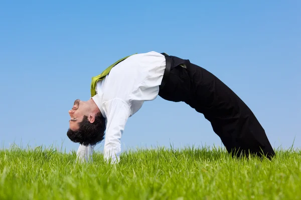 Joven empresario flexible estirar al aire libre en un día soleado — Foto de Stock