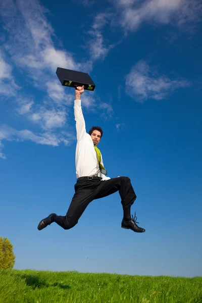 Щасливий бізнесмен з валізою на відкритому повітрі в сонячний день — стокове фото