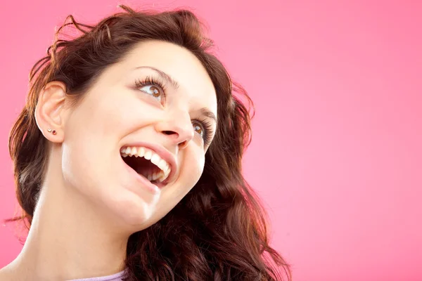 Krásná kudrnatá dívka úsměv portrét izolované na růžové — Stock fotografie