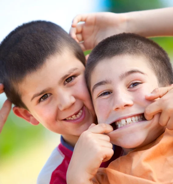 Красивые смешные молодые улыбающиеся братья играют на свежем воздухе в сельской местности — стоковое фото