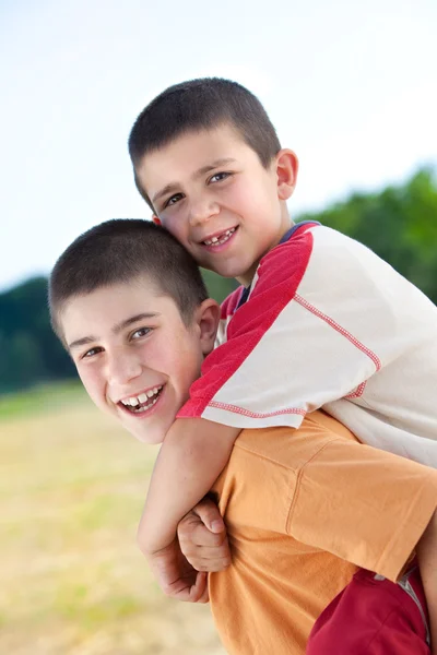 Piękne śmieszne młodych braci uśmiechający się grać odkryty w okolicy — Zdjęcie stockowe