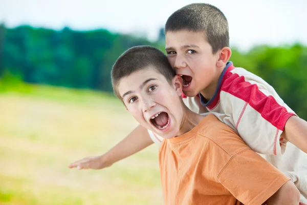 Hermoso divertido jóvenes sonrientes hermanos jugar al aire libre en el campo — Foto de Stock