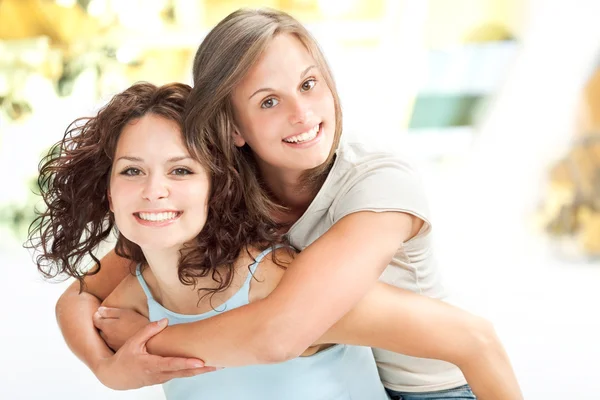 Beautiful young girl couple hug smile in a interior background — Stock Photo, Image