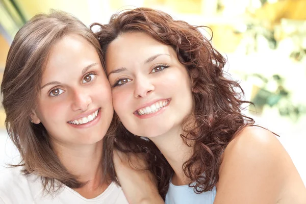 Szép fiatal lány pár ölelés mosolyt a belső háttérben — Stock Fotó