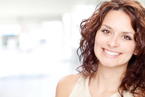 Bela morena menina sorriso retrato em um fundo interior — Fotografia de Stock