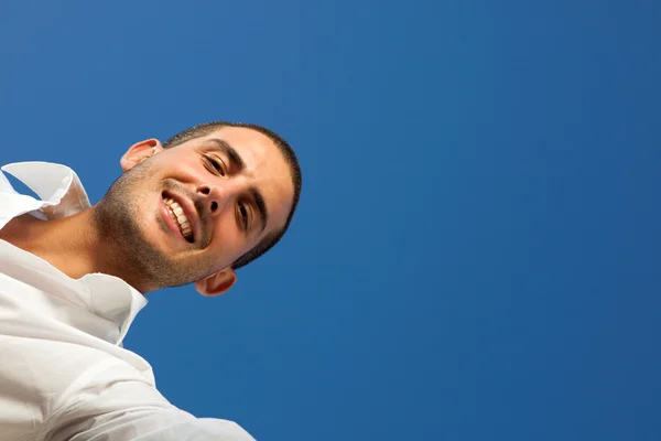 Joven guapo abre una caja al aire libre con cielo azul — Foto de Stock