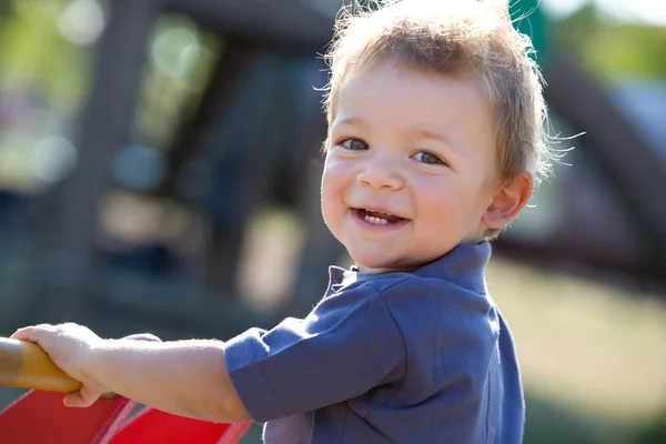 Glücklich lächelndes Kind, das draußen im Garten spielt — Stockfoto